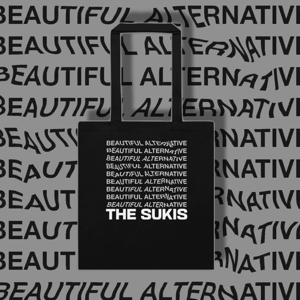 The Sukis Beautiful Alternative black tote bag on grey typographic background